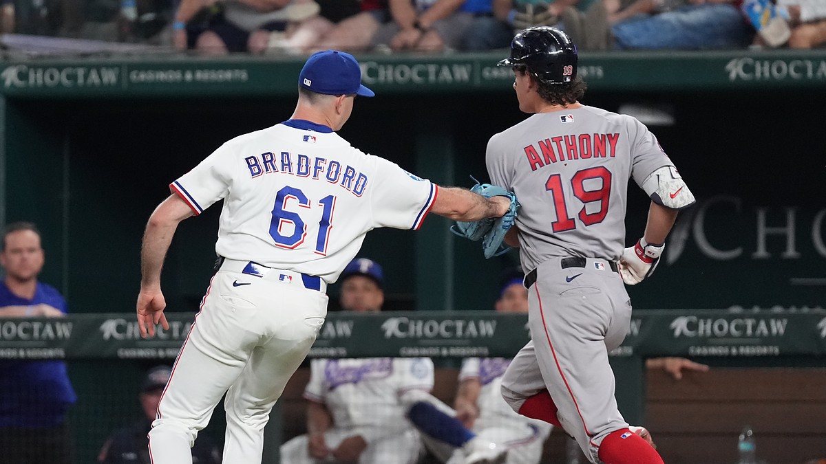 Texas Rangers pitcher Cody Bradford reaches out with his glove to tag Boston Red Sox runner Roman Anthony on the baseline.