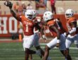 Texas Longhorns edge rusher Colin Simmons, No. 1, holds the ball overhead after recovering a fumble.