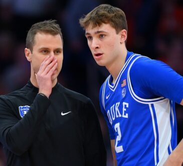Duke guard Cooper Flagg listens as head coach Jon Scheyer covers his mouth and talks during a stoppage.