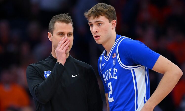 Duke guard Cooper Flagg listens as head coach Jon Scheyer covers his mouth and talks during a stoppage.