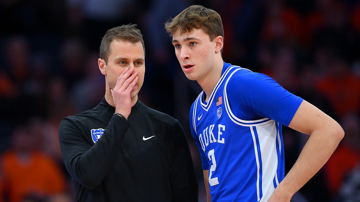 Duke guard Cooper Flagg listens as head coach Jon Scheyer covers his mouth and talks during a stoppage.