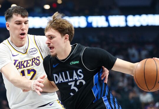 Dallas Mavericks forward Cooper Flagg dribbles with his right hand as Los Angeles Lakers forward Jake LaRavia defends.