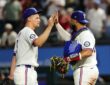 Texas Rangers shortstop Corey Seager, No. 5, high-fives catcher Elias Díaz, No. 35, after a win.