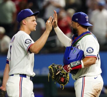 Texas Rangers shortstop Corey Seager, No. 5, high-fives catcher Elias Díaz, No. 35, after a win.