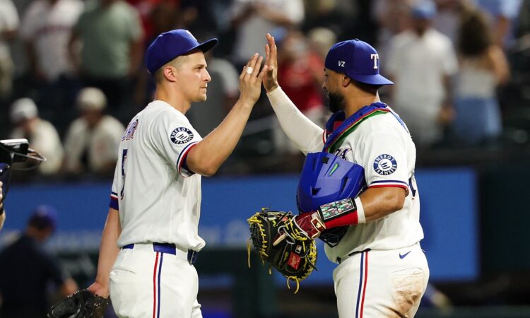 Texas Rangers shortstop Corey Seager, No. 5, high-fives catcher Elias Díaz, No. 35, after a win.