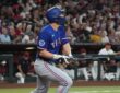 Texas Rangers shortstop Corey Seager follows through on a swing and watches the ball leave the park.
