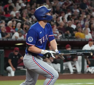 Texas Rangers shortstop Corey Seager follows through on a swing and watches the ball leave the park.