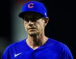 Chicago Cubs manager Craig Counsell walks off the field with a serious expression in a blue Cubs jersey.