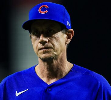Chicago Cubs manager Craig Counsell walks off the field with a serious expression in a blue Cubs jersey.
