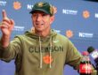 Clemson head coach Dabo Swinney raises an index finger while speaking at a postgame news conference.