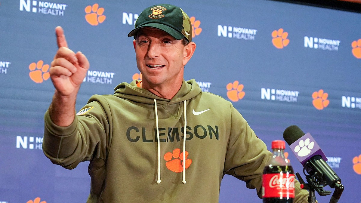 Clemson head coach Dabo Swinney raises an index finger while speaking at a postgame news conference.