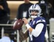 Dallas Cowboys quarterback Dak Prescott holds the ball in both hands during pregame warmups against the Chargers.