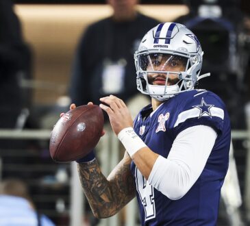 Dallas Cowboys quarterback Dak Prescott holds the ball in both hands during pregame warmups against the Chargers.