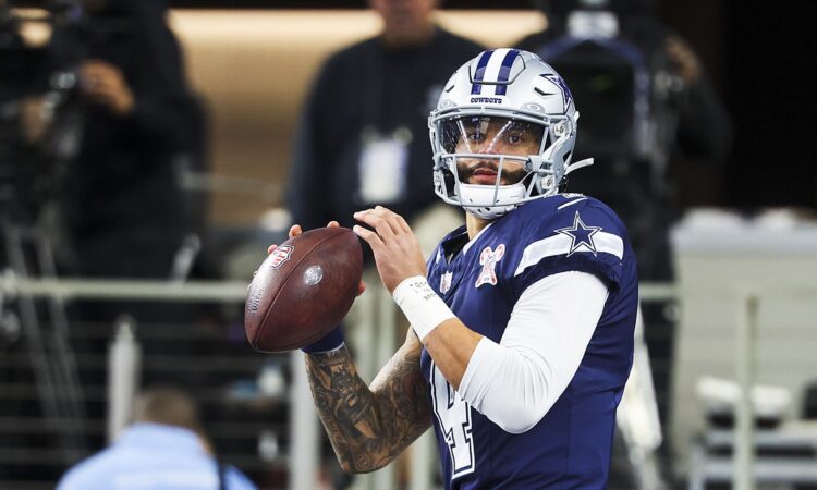 Dallas Cowboys quarterback Dak Prescott holds the ball in both hands during pregame warmups against the Chargers.