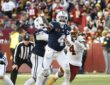 Dallas Cowboys quarterback Dak Prescott throws downfield as Washington Commanders linebacker Frankie Luvu closes in.