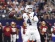 Dallas Cowboys quarterback Dak Prescott cocks his arm to throw from the pocket with the Commanders sideline behind him.