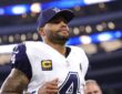Cowboys quarterback Dak Prescott, wearing a navy cap and his captain’s patch, jogs off the field inside the stadium.