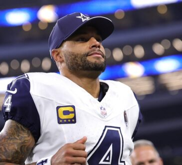 Cowboys quarterback Dak Prescott, wearing a navy cap and his captain’s patch, jogs off the field inside the stadium.