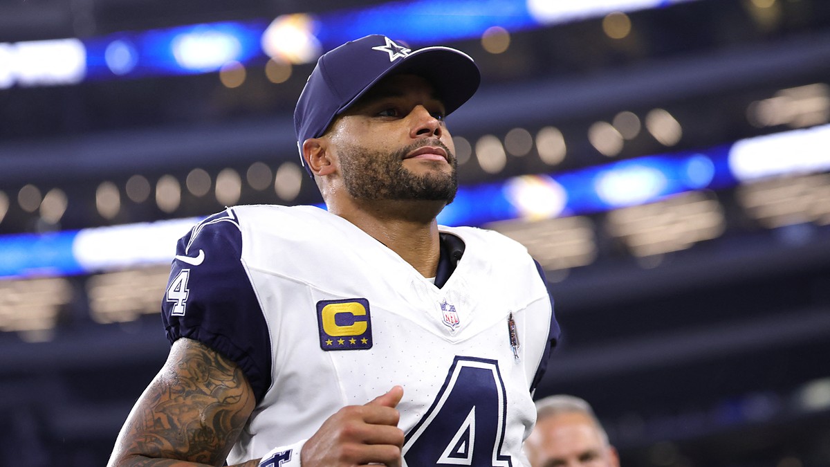 Cowboys quarterback Dak Prescott, wearing a navy cap and his captain’s patch, jogs off the field inside the stadium.