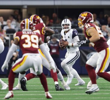 Cowboys quarterback Dak Prescott sets up in the pocket with the football as linemen battle around him.