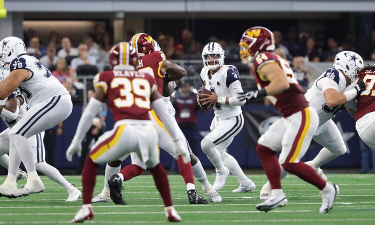 Cowboys quarterback Dak Prescott sets up in the pocket with the football as linemen battle around him.