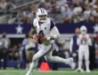 Cowboys quarterback Dak Prescott scrambles to his right with the football in both hands as he looks downfield.