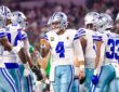 Dallas Cowboys quarterback Dak Prescott raises a fist toward wide receiver George Pickens in the huddle against the Eagles.