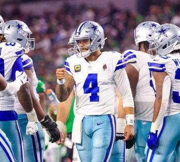 Dallas Cowboys quarterback Dak Prescott raises a fist toward wide receiver George Pickens in the huddle against the Eagles.