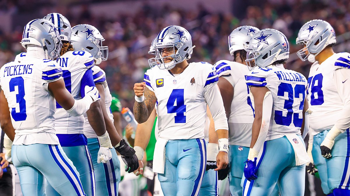 Dallas Cowboys quarterback Dak Prescott raises a fist toward wide receiver George Pickens in the huddle against the Eagles.