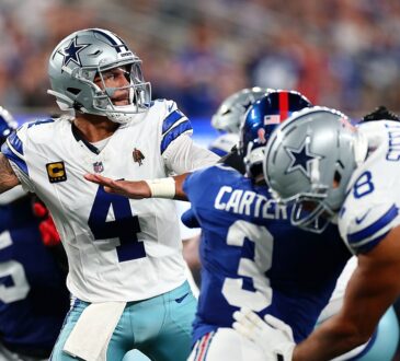 Dallas Cowboys quarterback Dak Prescott winds up to throw as blockers and a Giants rusher fill the pocket.
