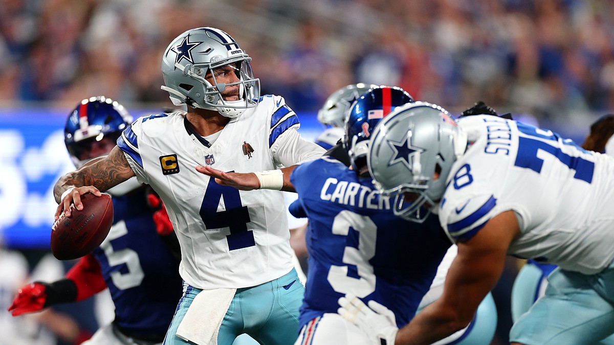 Dallas Cowboys quarterback Dak Prescott winds up to throw as blockers and a Giants rusher fill the pocket.