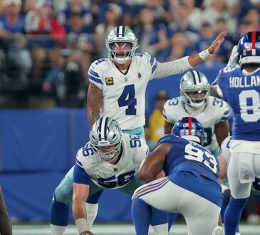Cowboys quarterback Dak Prescott points out a defender at the line of scrimmage with center Cooper Beebe over the ball.