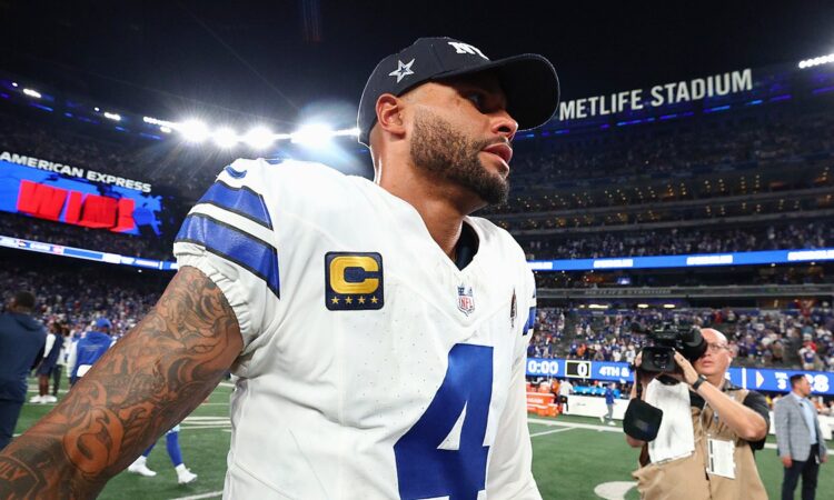 Dallas Cowboys quarterback Dak Prescott walks off the field in a team cap after a loss to the Giants.