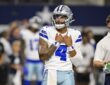 Dallas Cowboys quarterback Dak Prescott adjusts his jersey as he looks on before a game against the Saints.