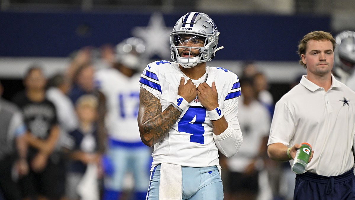Dallas Cowboys quarterback Dak Prescott adjusts his jersey as he looks on before a game against the Saints.