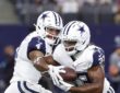 Dallas Cowboys quarterback Dak Prescott hands the ball to running back Javonte Williams during pregame warmups.