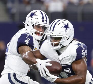 Dallas Cowboys quarterback Dak Prescott hands the ball to running back Javonte Williams during pregame warmups.
