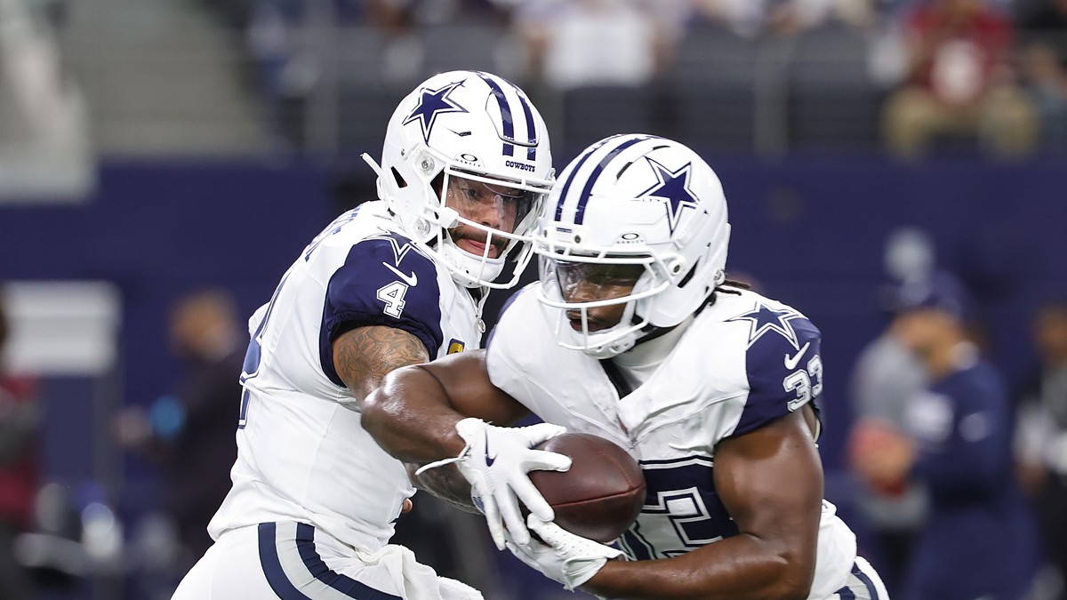 Dallas Cowboys quarterback Dak Prescott hands the ball to running back Javonte Williams during pregame warmups.