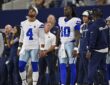 Dallas Cowboys quarterbacks Dak Prescott and Joe Milton III watch from the sideline at AT&T Stadium.