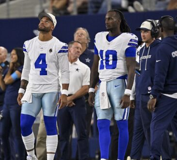 Dallas Cowboys quarterbacks Dak Prescott and Joe Milton III watch from the sideline at AT&T Stadium.