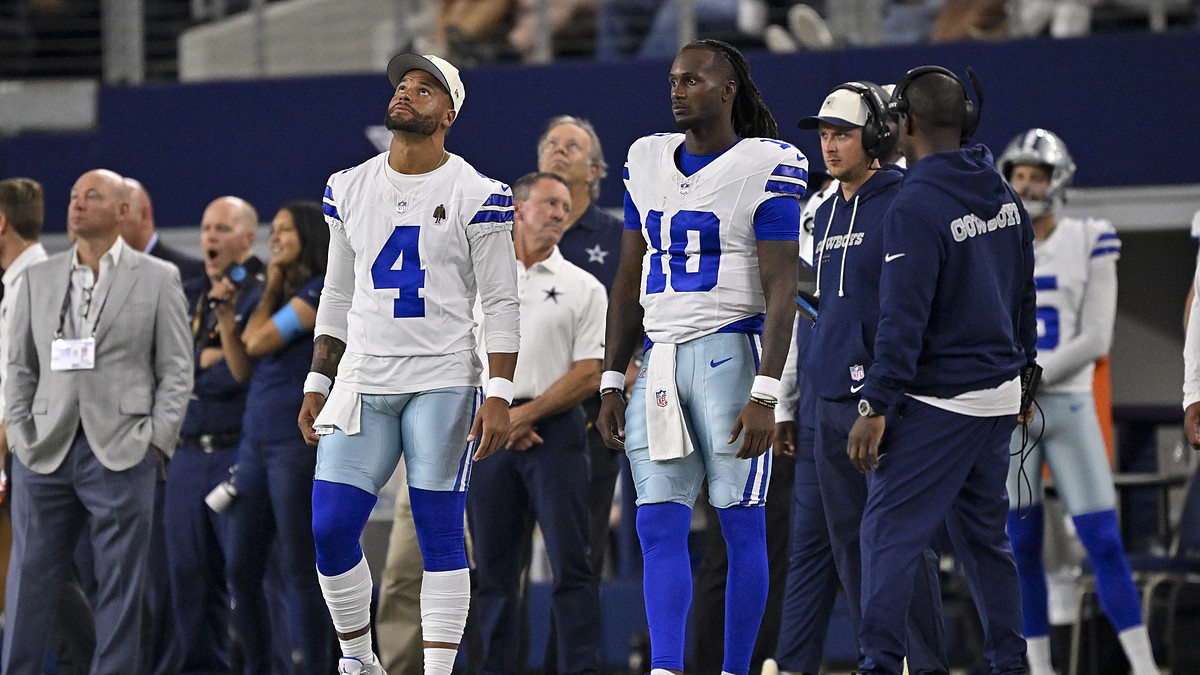 Dallas Cowboys quarterbacks Dak Prescott and Joe Milton III watch from the sideline at AT&T Stadium.