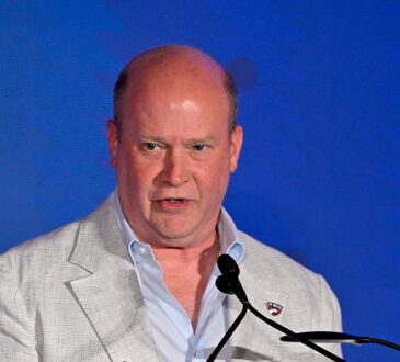 FC Dallas president Dan Hunt speaks at a podium during the National Soccer Hall of Fame induction ceremony.
