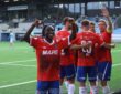 KIL Toppfotball players in red celebrate in front of the away supporters after a goal.