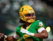 Oregon Ducks quarterback Dante Moore, No. 5, cocks his arm to throw during pregame warmups.