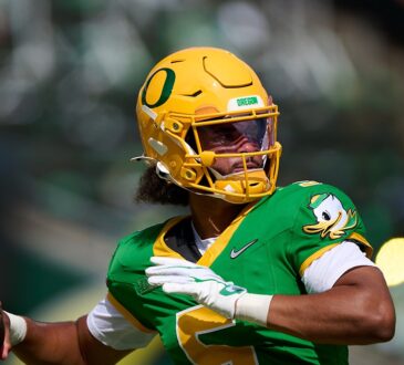 Oregon Ducks quarterback Dante Moore, No. 5, cocks his arm to throw during pregame warmups.