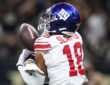 New York Giants wide receiver Darius Slayton reaches for a pass as a Saints cornerback covers him from behind.