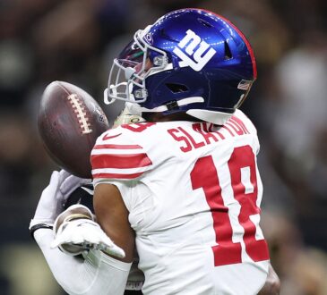 New York Giants wide receiver Darius Slayton reaches for a pass as a Saints cornerback covers him from behind.