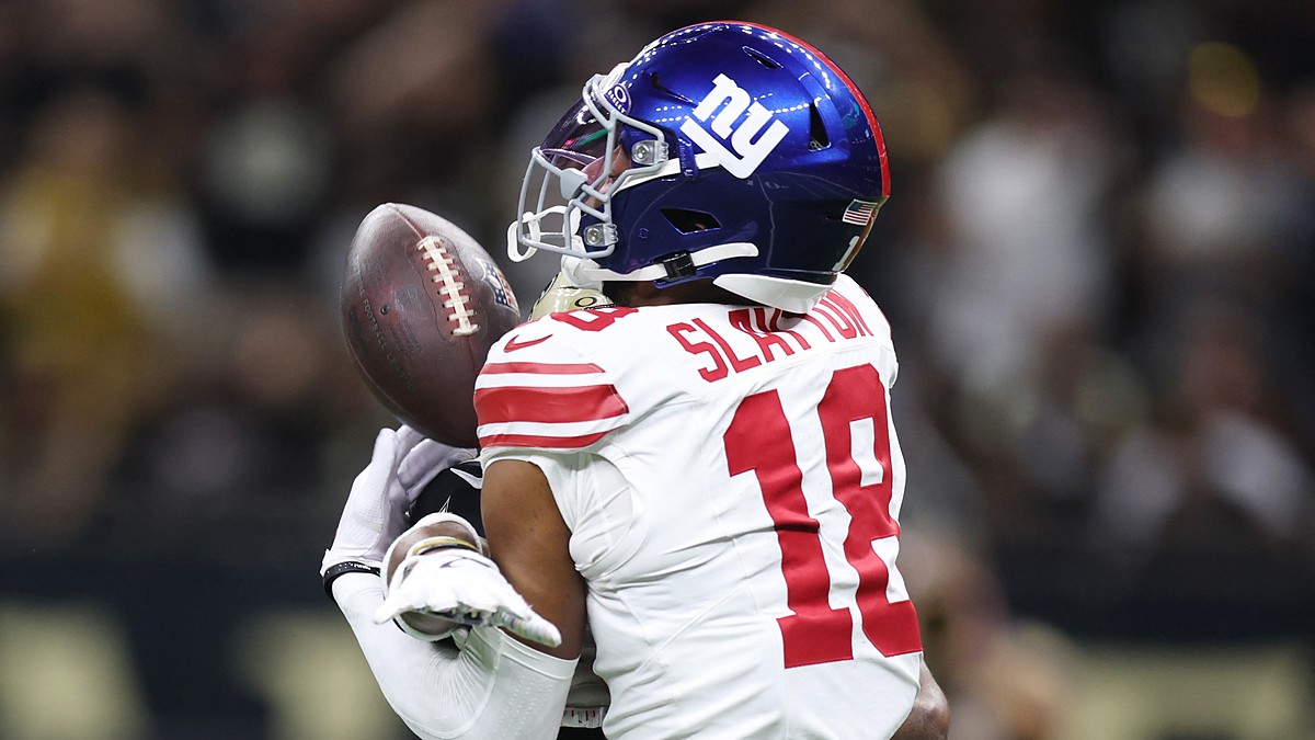 New York Giants wide receiver Darius Slayton reaches for a pass as a Saints cornerback covers him from behind.