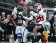 San Francisco 49ers cornerback Darrell Luter Jr. reaches back to break up a pass as the ball floats free.