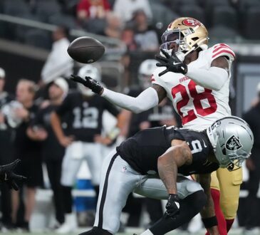 San Francisco 49ers cornerback Darrell Luter Jr. reaches back to break up a pass as the ball floats free.